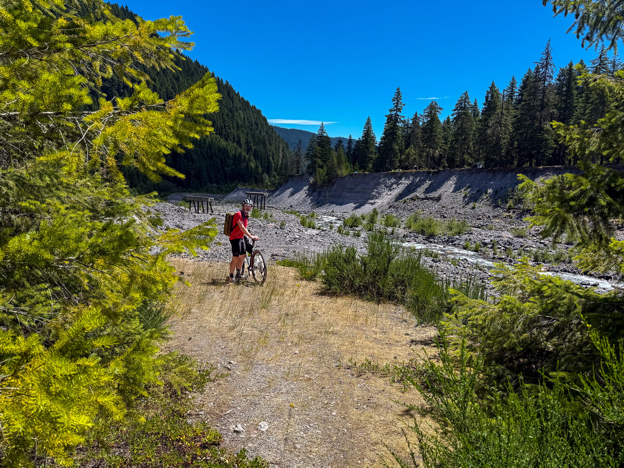 A rider crossing the broad braided gravel valley of the Muddy River